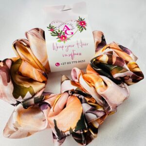 Floral peach scrunchie hair accessory with soft fabric and delicate flower pattern